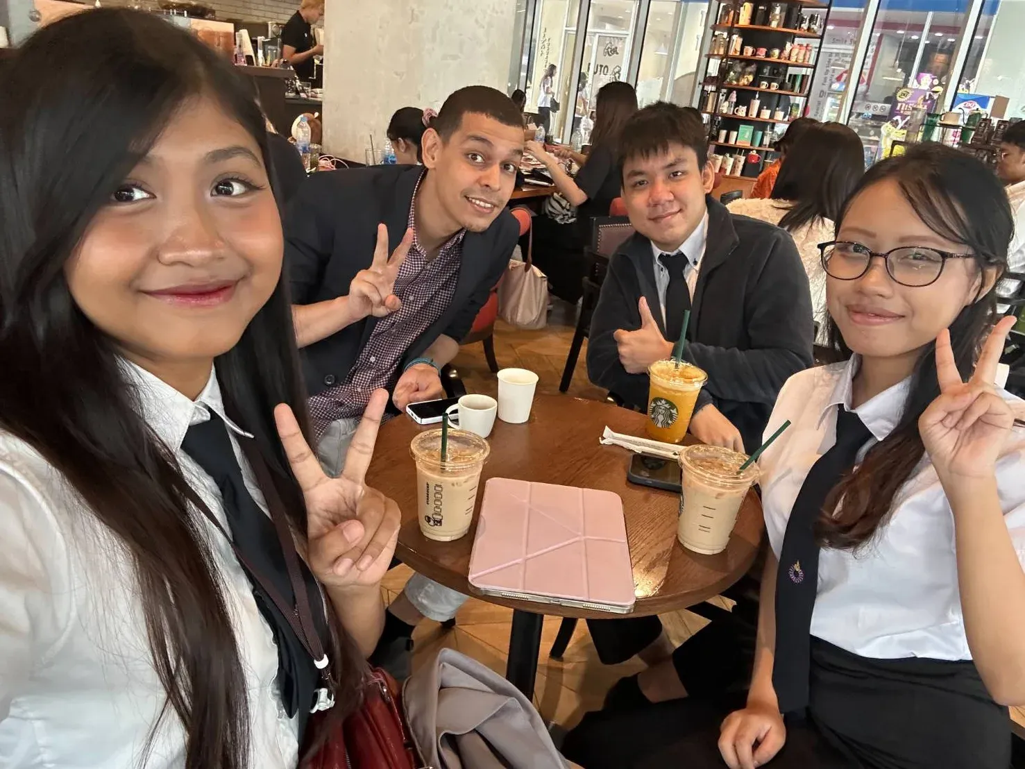 The research team smiling around a café table after the conference